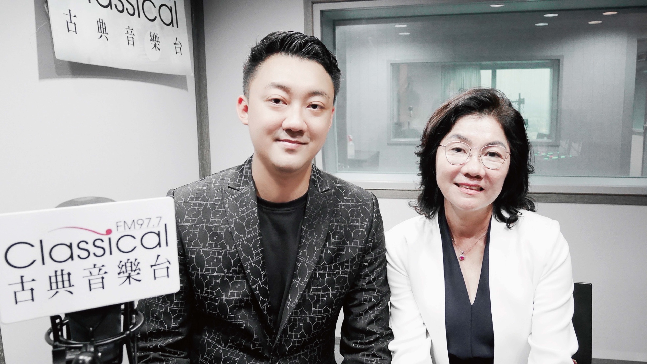 古典音樂台 FM97.7 錄音室內合影，桌上為電台立牌與麥克風